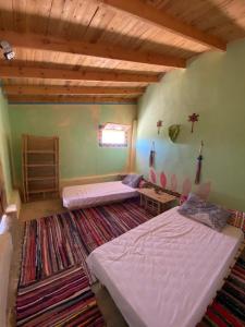 a bedroom with two beds and a rug at Hidden place in Siwa