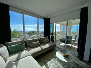 a living room with a couch and large windows at Excelsior I Sea View Apartment in Maspalomas