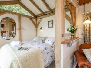 a bedroom with a bed and a mirror at The Jenny Wrennery in Rugeley