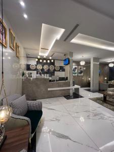 ein Wohnzimmer mit einem großen weißen Marmorboden in der Unterkunft فندق التلال الخضراء in An Nimāş