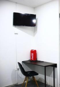 a desk with a chair and a television on a wall at Loft Hermoso con Jacuzzi in Villahermosa
