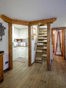 a kitchen with wooden floors and a spiral staircase at Bellissimo appartamento con vista sul Cervino in Breuil-Cervinia