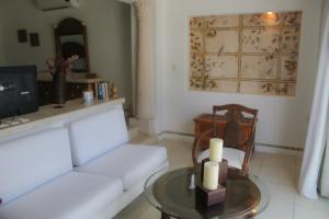 uma sala de estar com um sofá branco e uma mesa em Villa Santorini em Uaymitun