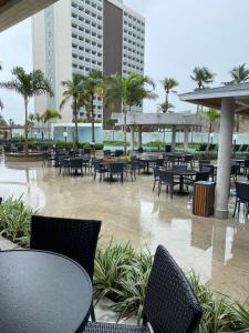 a patio with tables and chairs and palm trees at Salinas Exclusive Resort in Salinópolis