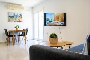 un soggiorno con divano e TV a parete di Apartament New Cathedral a Siviglia