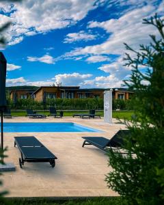 a pool with tables and benches in front of a building at Shurra in Buzau