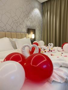 a bed with red and white balloons in the shape of hearts at فندق التلال الخضراء in An Nimāş +75 photos