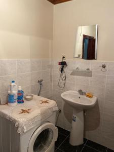 een badkamer met een toilet, een wastafel en een spiegel bij Rooftop apartment with a big garden in Kocaeli