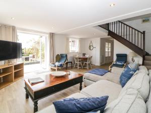 a living room with a couch and a tv at The Holt in Sidmouth