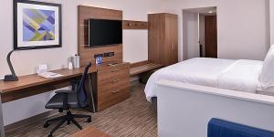 Holiday Inn Express Hotel and Suites Mesquite, an IHG Hotel في ميسكوايت: غرفة في الفندق بها سرير ومكتب وبه جهاز كمبيوتر