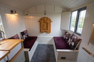 um quarto com dois bancos numa pequena casa em Shepherds Hut em Lonmore