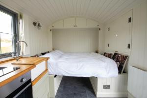 a small bedroom with a bed in the middle of it at Shepherds Hut in Lonmore