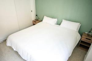 una camera con un letto bianco con due cuscini di Apartament New Cathedral a Siviglia
