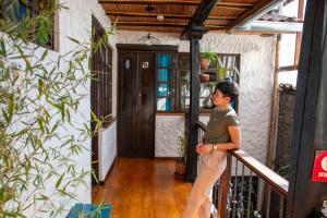 クエンカにあるHostal Restaurant La Cigaleの家の手すりに立つ女
