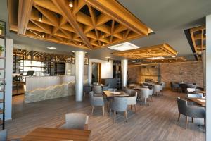a restaurant with wooden ceilings and tables and chairs at Hotel Castello in Prizren