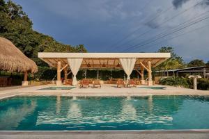 einen Pavillon mit Stühlen und einem Pool in der Unterkunft PETRA SANTA HOTEL BOUTIQUE in Pereira