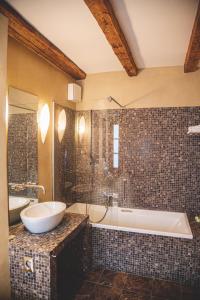 a bathroom with a tub and a sink and a bath tub at Heritage Hotel Kukuriku in Kastav