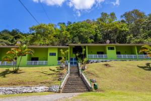 ein grünes Haus mit Treppe davor in der Unterkunft Estância Solazer in Santa Isabel