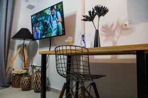 a room with a desk with a television and a chair at Albatross Volos Luxury Apartment in Volos
