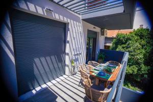 - une table et des chaises sur une terrasse avec un portail dans l'établissement Albatross Volos Luxury Apartment, à Vólos