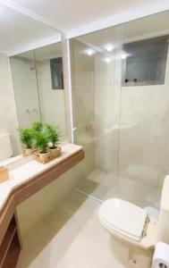 uma casa de banho com um WC e uma cabina de duche em vidro. em Tudo próximo a você em São Paulo