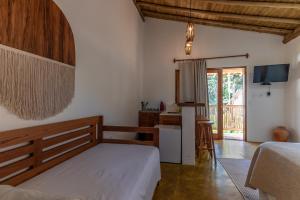 Cet appartement comprend une chambre avec un lit et une cuisine avec une table. dans l'établissement Casa Luar Trancoso, à Trancoso