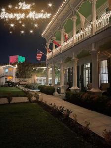 un gran edificio blanco con banderas americanas por la noche en The George Manor, en Galveston