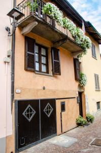 budynek z czarnymi drzwiami garażowymi i balkonem w obiekcie Holiday House Antica Dimora Soggiorni in langa centro storico La Morra w mieście La Morra