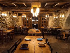 uma grande sala de jantar com mesas e cadeiras de madeira em Fogar de Breogán em Pontevedra