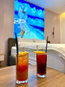drie cocktails zittend op een houten tafel voor een bed bij Marinus Hotel in Ulcinj