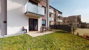 a person sitting on a bench in the backyard of a building at Apartament Fibra Americano in Rybnik