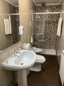 een badkamer met een wastafel, een toilet en een douche bij Residencial Solar da Estação in Barcelos