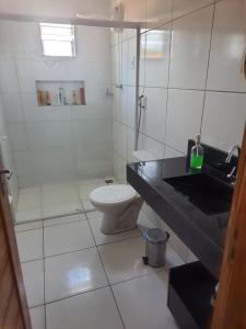 Baño blanco con aseo y lavamanos en Lá na Roça - Belezas do Monte Chalé, Suítes & Restaurante en Monte das Gameleiras