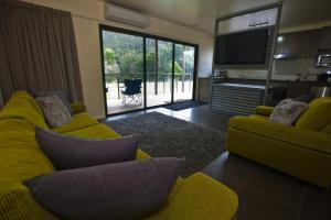 a living room with a yellow couch and a television at Tyenna River Cottages in Tyenna
