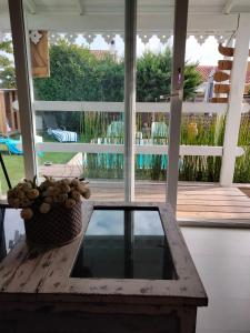 a table on a screened in porch with a view of a pool at La cabane et sa cascade in Lège-Cap-Ferret