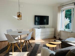 ein Wohnzimmer mit Tisch und Fernseher in der Unterkunft Connect 9.3 in Dorum Neufeld