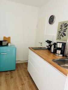 a kitchen with a sink and a blue refrigerator at Connect 9.3 in Dorum-Neufeld