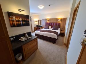 a hotel room with a large bed and a desk at The Royal Hotel in Liverpool