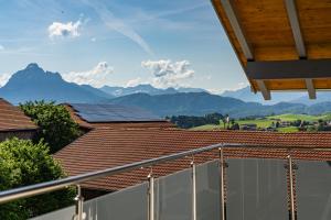 uma vista para as montanhas a partir de uma varanda de uma casa em Gästehaus Beim Huber em Hopferau