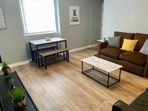 a living room with a couch and two tables at Pendle House - Apartment 3 in Colwyn Bay
