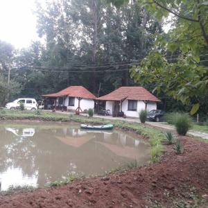 ein kleines Haus mit einem Teich davor in der Unterkunft Sljivik in Niš