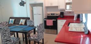 a kitchen with a table and chairs and a refrigerator at Pura Vida Condo in Tamarindo