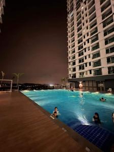 dos personas nadando en una piscina por la noche en Lovely Luxury 3 Br 2Bath @Vista Bangi, en Kajang