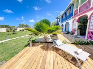 a bench on a wooden deck in front of a house at Costa Blue, Orient Bay beach front, XXL pools in Orient Bay +19 photos