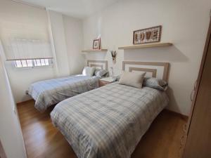 - une chambre avec 2 lits et une fenêtre dans l'établissement Ático Granada al Sol (terraza vistas montaña), à La Zubia
