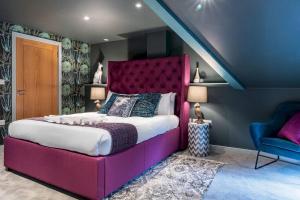 a bedroom with a large purple bed and a chair at Style & opulence in Georgian chapel w Parking in Bath