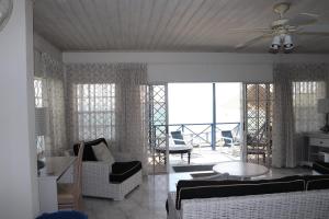 a living room with chairs and a ceiling fan at Little Reef Villa in Saint James