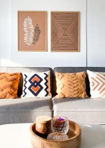 a living room with a couch and a table with pillows at Sol Apartment - self check-in, free parking in Oradea