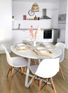 a white dining room with a white table and chairs at Sol Apartment - self check-in, free parking in Oradea +13 photos