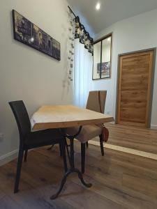 una mesa de madera y sillas en una habitación en Le 28 Frater, en Millau